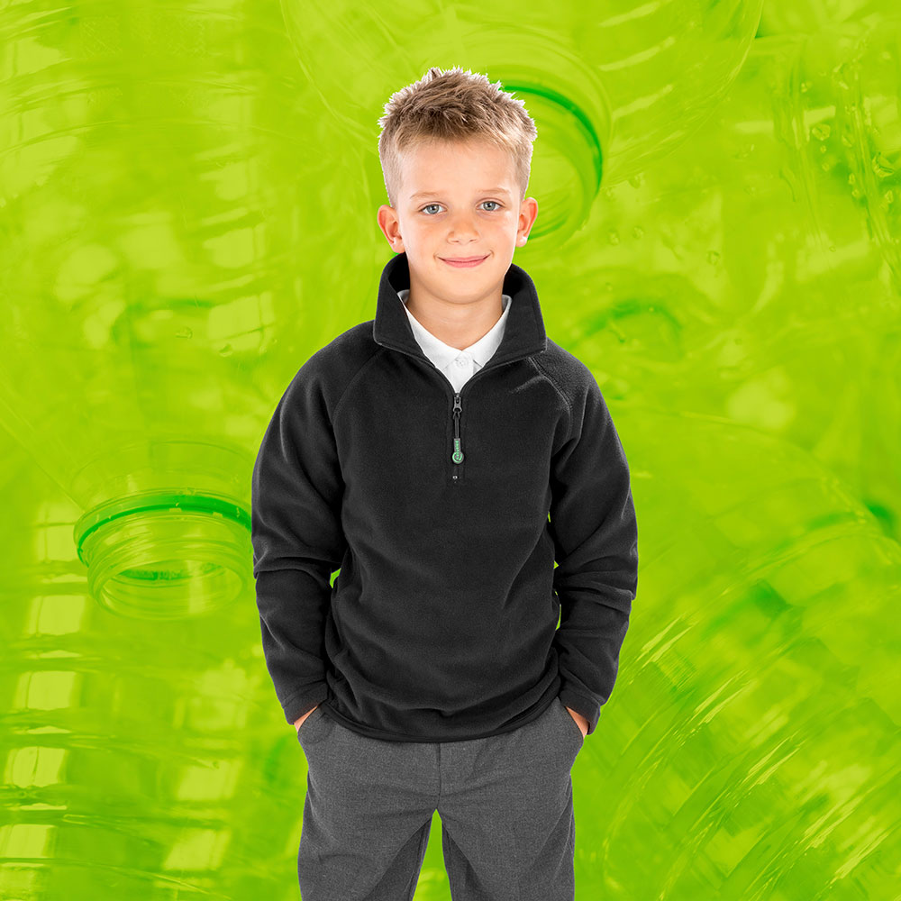 Young boy in grey Result fleece against bright green background