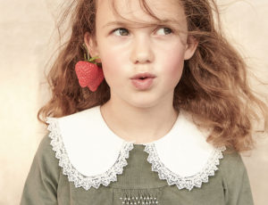 A young girl wearing a Strawberries & Cream Dress