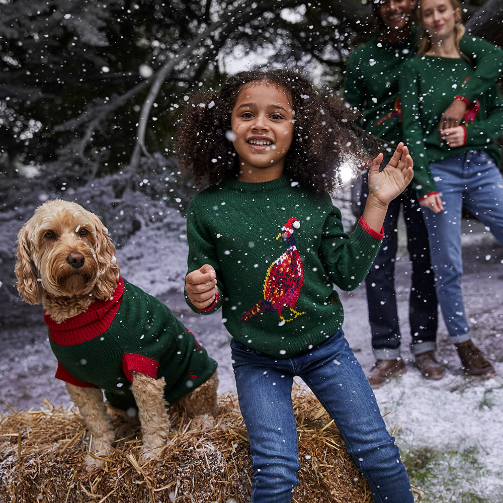Young girl in green knitted Joules sweater and her dog - Joules Christmas trading