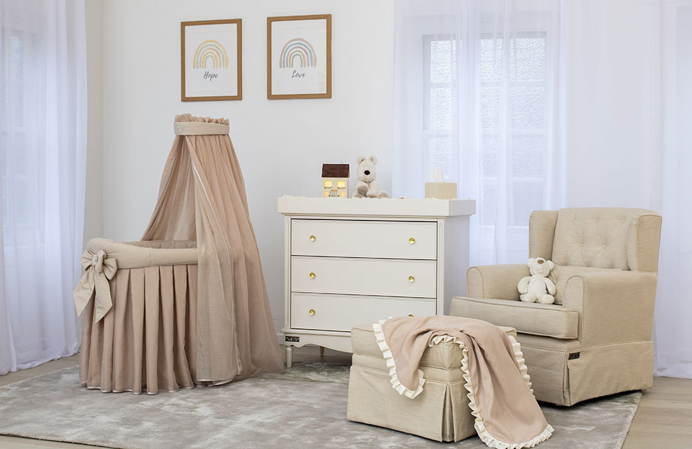 Bedroom with cot and set of drawers with beige baby blanket and accessories