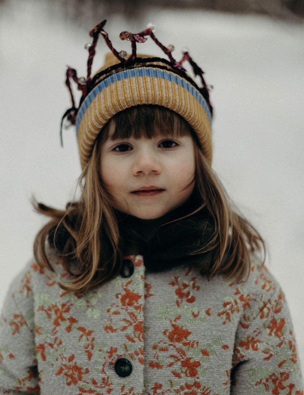 Girl stood in snow wearing Paade Mode childrenswear.