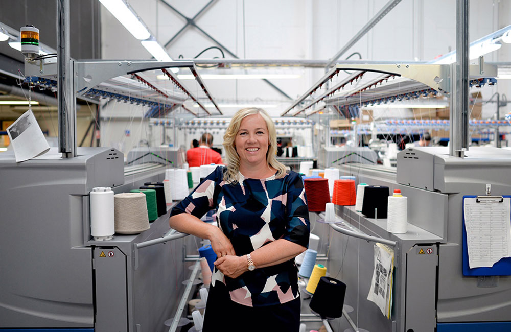 Blonde haired woman stood in UK fabric factory