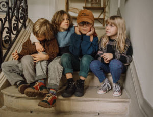 Four children sat together on some steps
