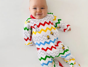 Baby boy in Lil' Cubs Peanuts branded baby gro with colourful zigzag pattern