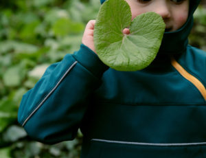 Child holding a leaf wearing Kidunk eco range