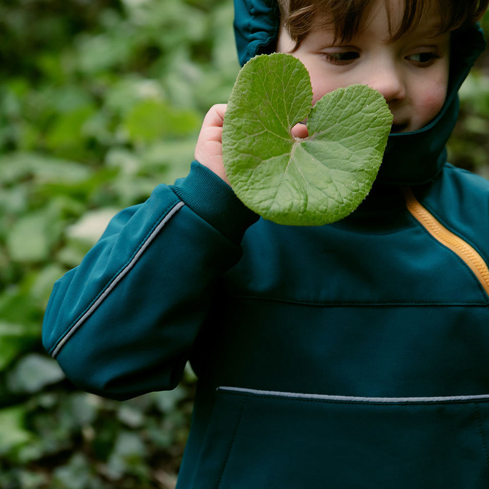 Child holding a leaf wearing Kidunk eco range
