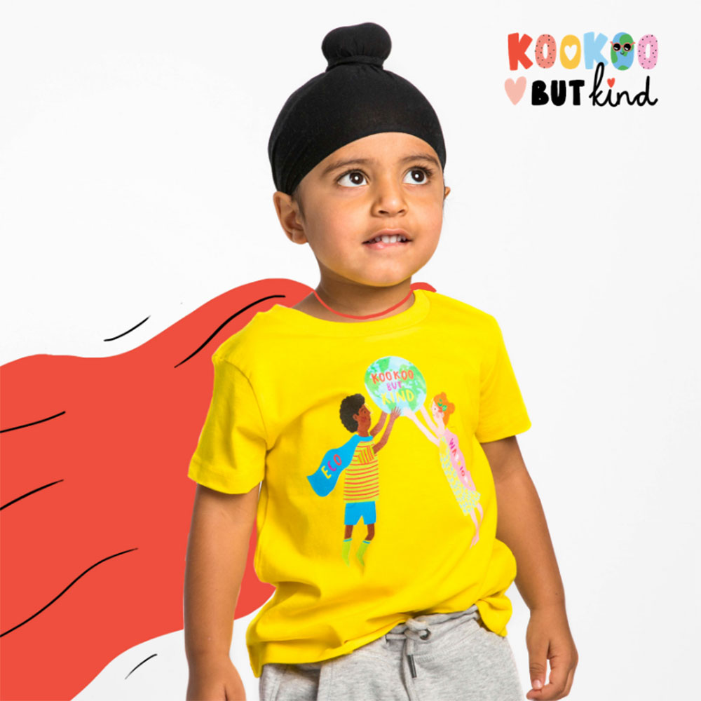 Boy in black turban wearing yellow T Shirt and with a drawn on red cape