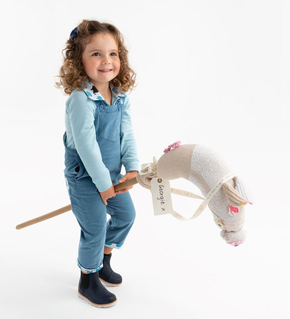 Young girl riding a wooden toy horse