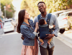 A couple carrying a baby in a baby carrier