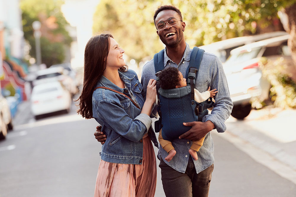 A couple carrying a baby in a baby carrier