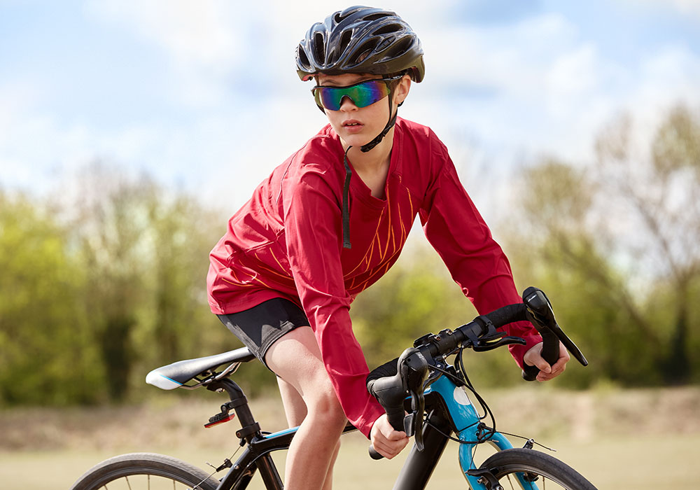 Boy in red Beech sports shirt riding a bike