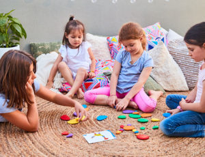 Four young girls sat playing with colourful Edx education toys