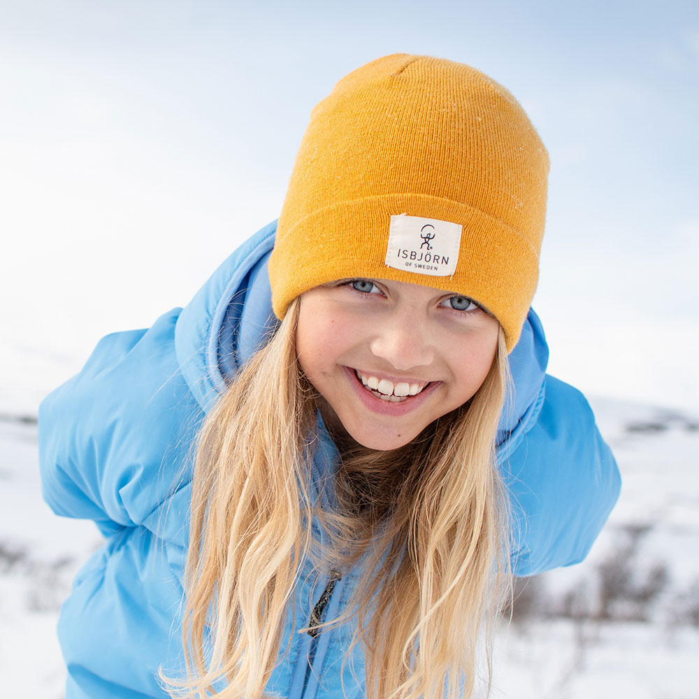 Young girl in yellow beanie hat and blue winter jacket