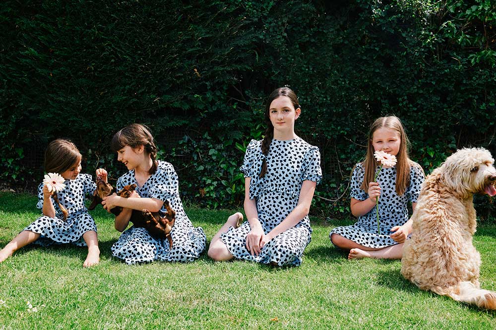 Four children and a dog sat in the garden together