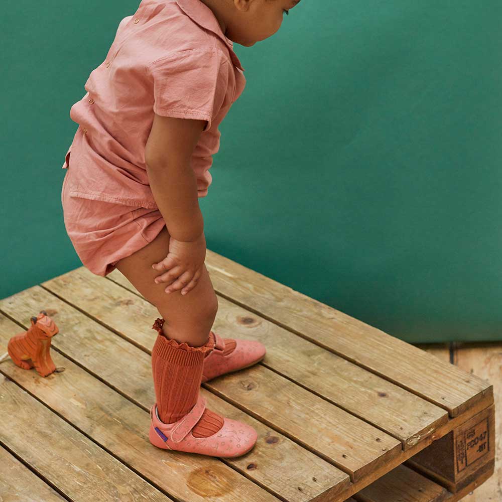 A young toddler wearing Poco Nido footwear
