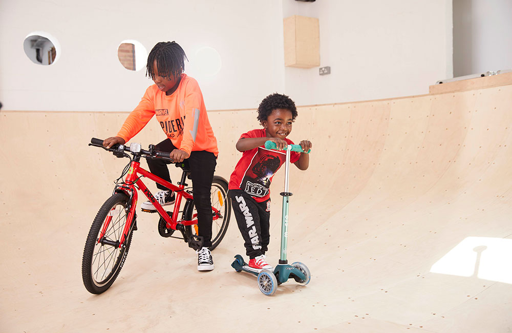 Two young boys on bikes inside Fabric Flavours skate park