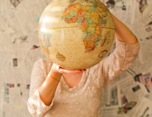 Woman holding a globe in front of her face - Mintel report on sustainability issues