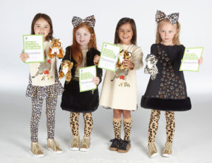 Children holding WWF adoption certificates wearing the new Wild About Big Cats collection