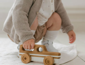 Small boy holding a handmade wooden car by Blue Brontide