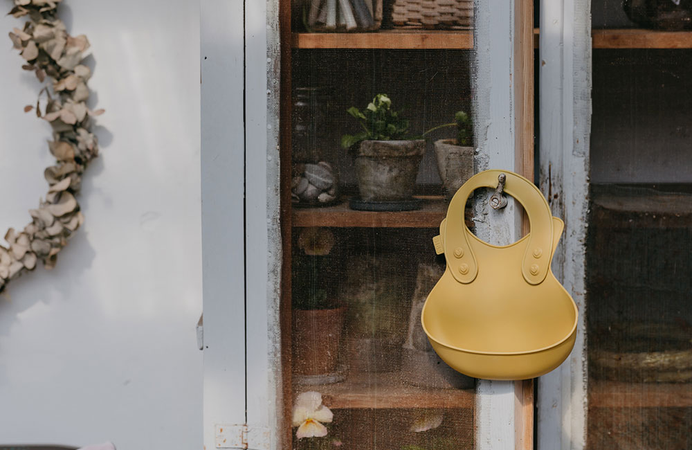 pastel yellow childrens bibs handing on a door handle