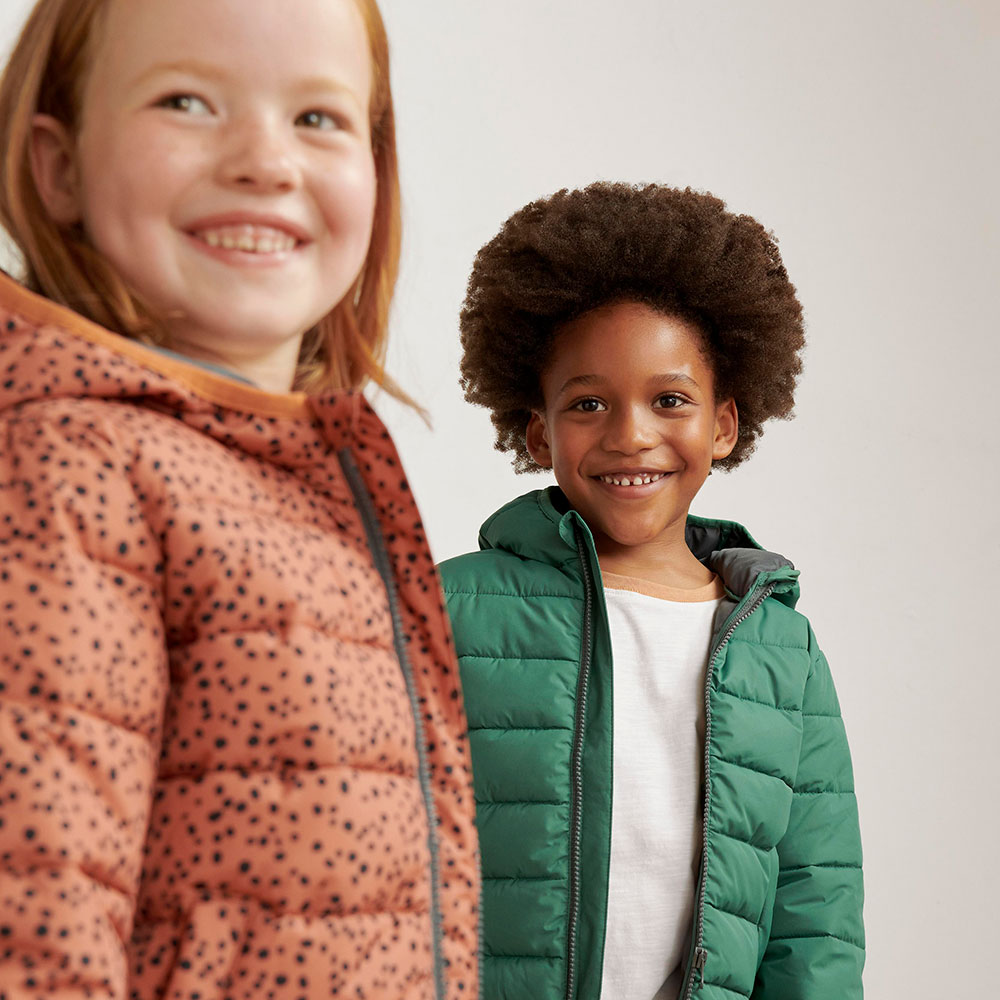 Young boy in green coat and girl wearing orange Anyday coat by John Lewis