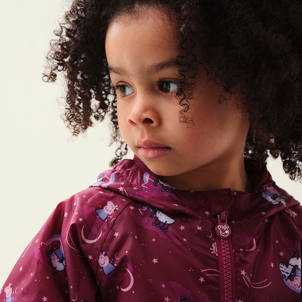 Young curly haired girl in purple peppa pig jacket by Regatta