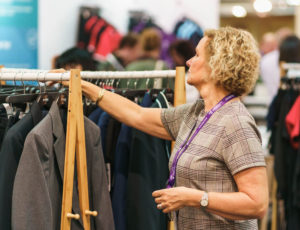 Woman looking at rails of Schoolwear at trade show