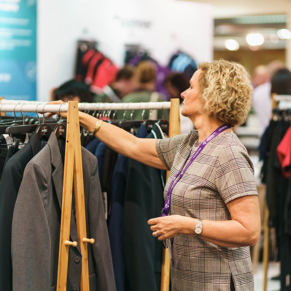 Woman looking at rails of Schoolwear at trade show