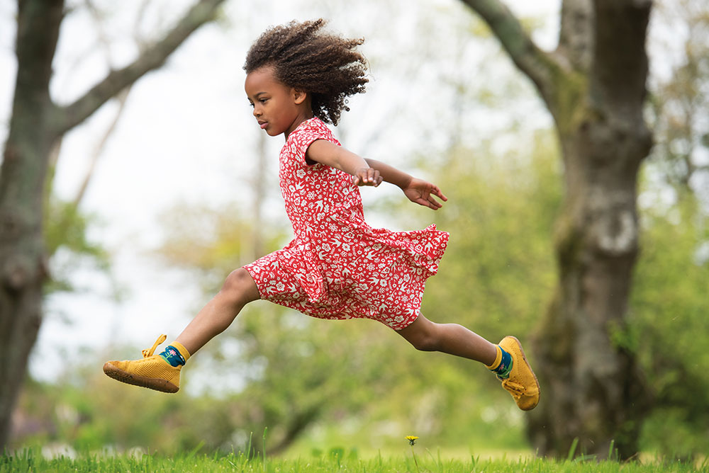 A young girl jumping through the air