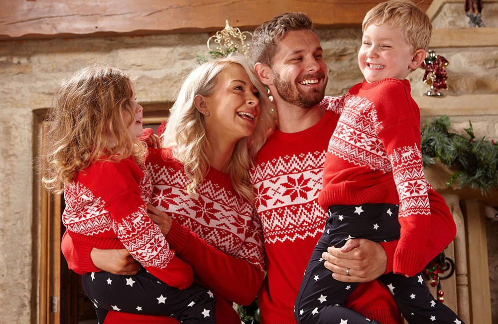 Family wearing matching red and white christmas jumpers