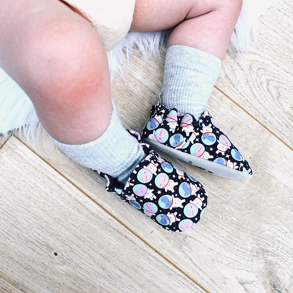 Babies legs wearing black Poco Nido design baby shoes