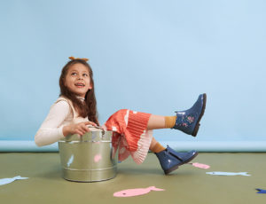 A young girl sat in a silver bucket sat on the floor