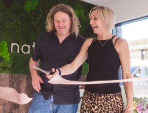 man and woman cutting the ribbon at the opening of Natural Baby Shower new headquarters