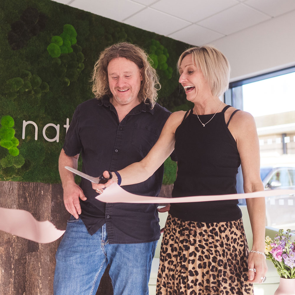 man and woman cutting the ribbon at the opening of Natural Baby Shower new headquarters
