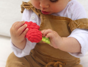 Baby boy holding red strawberry from Oli&Carol Nuts and Forest Fruits collection
