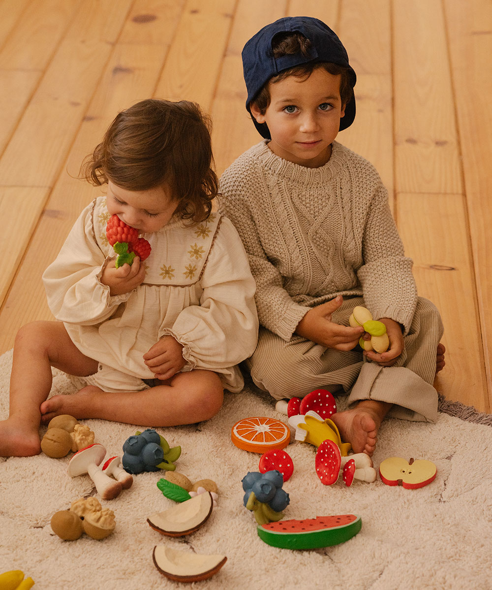 Two young children sat playing with Oli&Carol Nuts and Forest Fruits collection