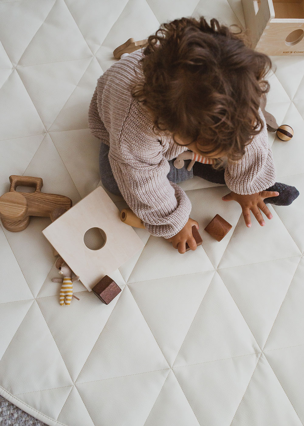 child photographed from above playing on Singing Ant playmat