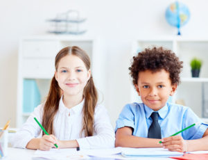 Boy and girl sat at a desk at school