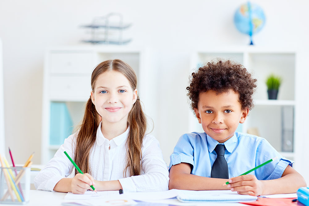 Boy and girl sat at a desk at school