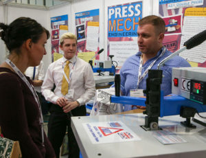 An exhibitor speaking to a visitor at Printwear & Promotion LIVE!