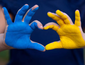 Child with painted hands - one blue, one yellow