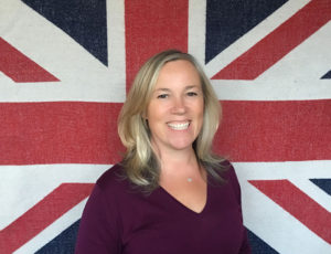 Kate hills with blonde hair stood in front of Union flag