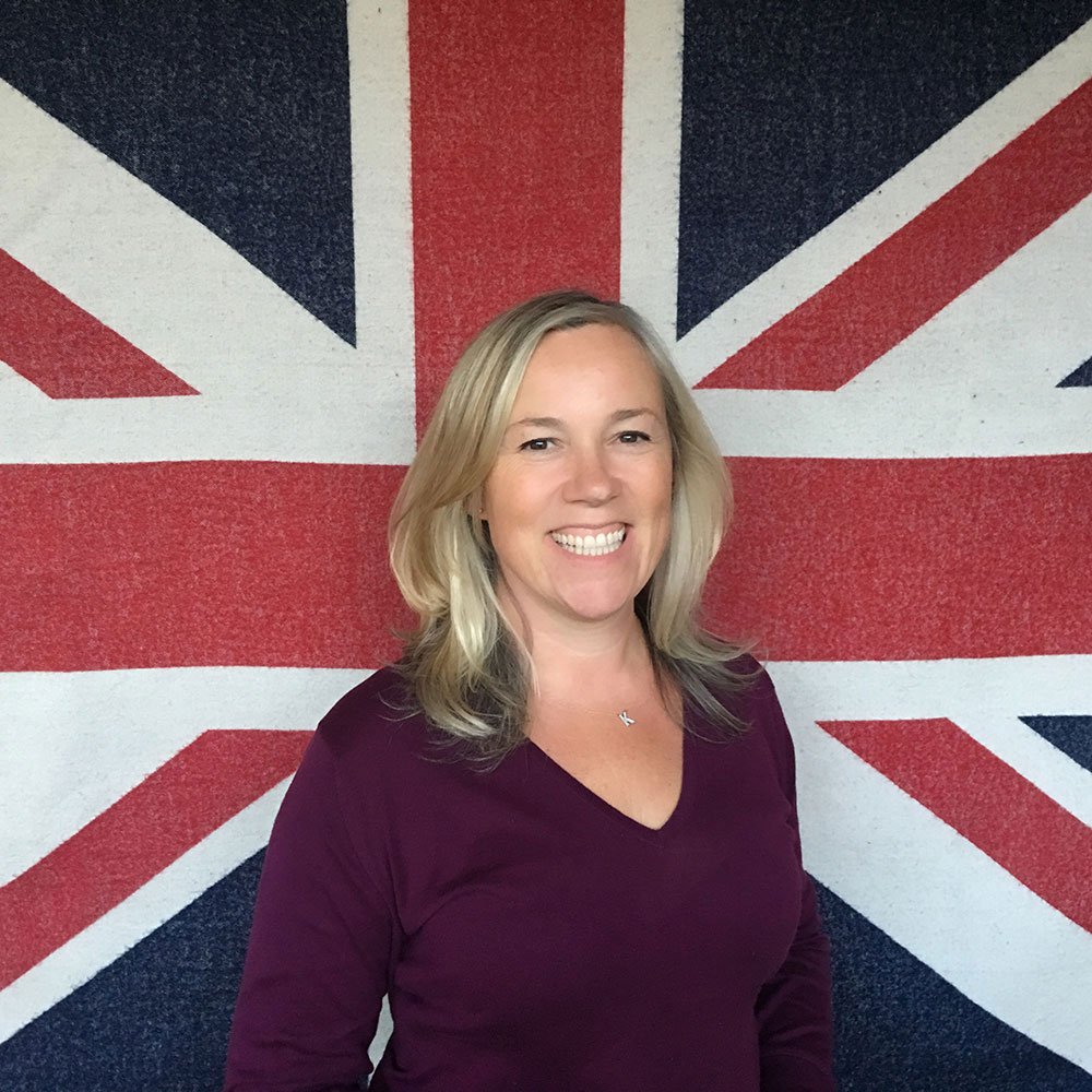 Kate hills with blonde hair stood in front of Union flag