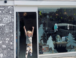 Young boy jumping outside The Small Stuff retail store
