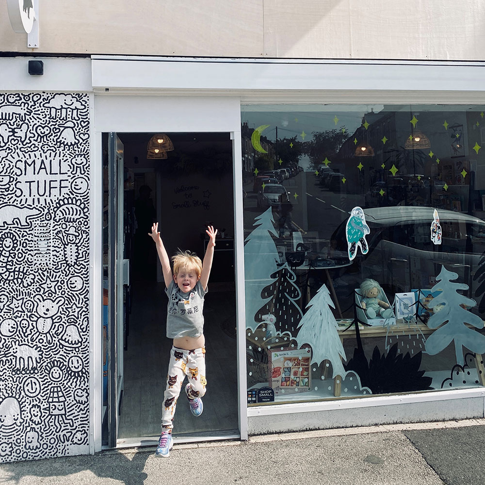 Young boy jumping outside The Small Stuff retail store