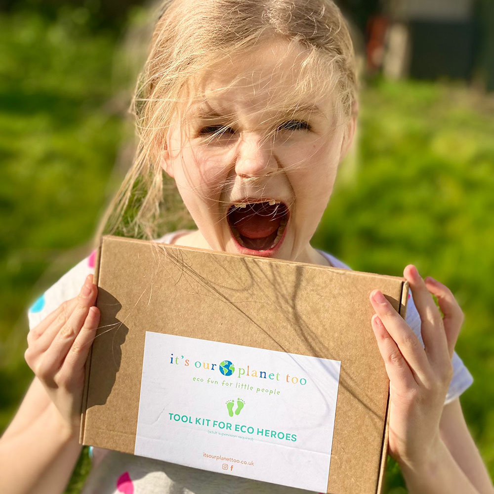 young girl holding card eco subscription box for Earth Day