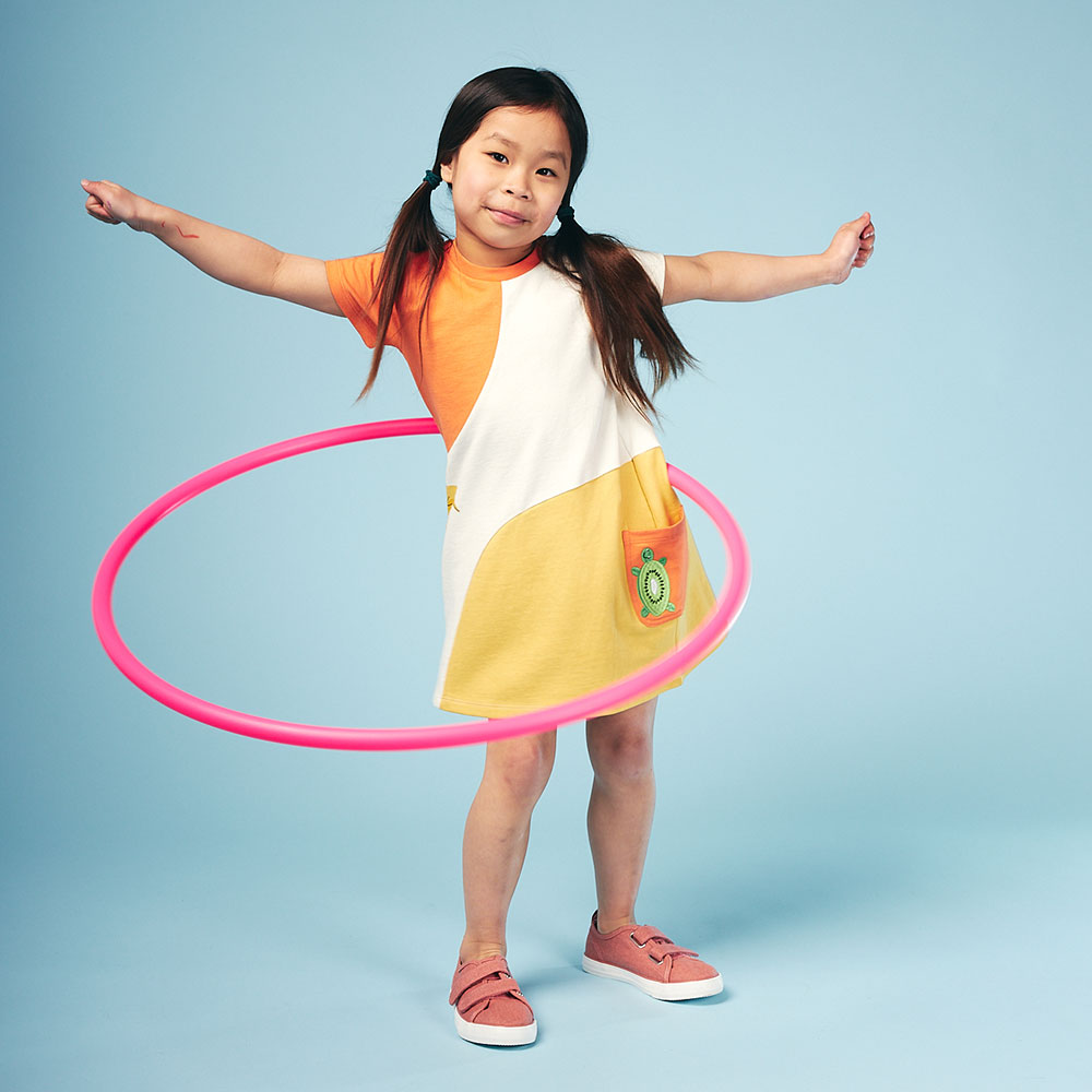 Young girl wearing a dress by Lucy & Sam doing hoola Hoop