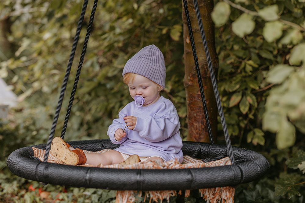 A young baby with a pacifier in its mouth