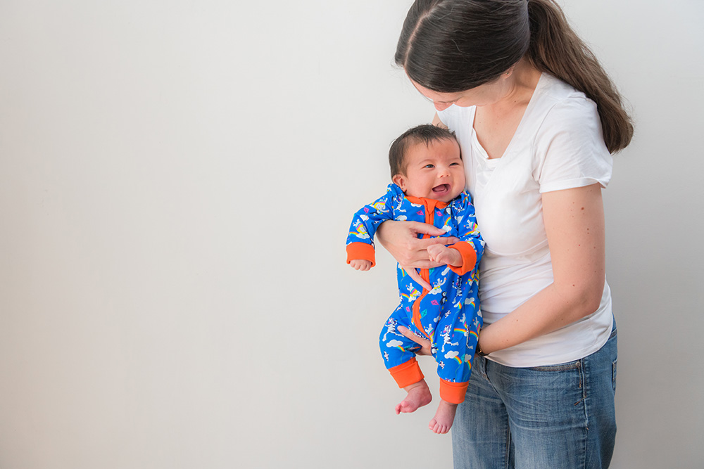 A mother stood up holding a baby