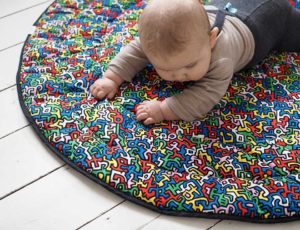 A young baby laid on a sensory playmat